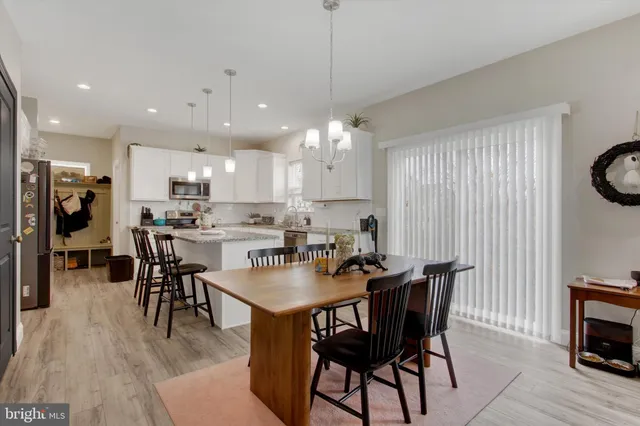 a kitchen with a dining table chairs stainless steel appliances and cabinets