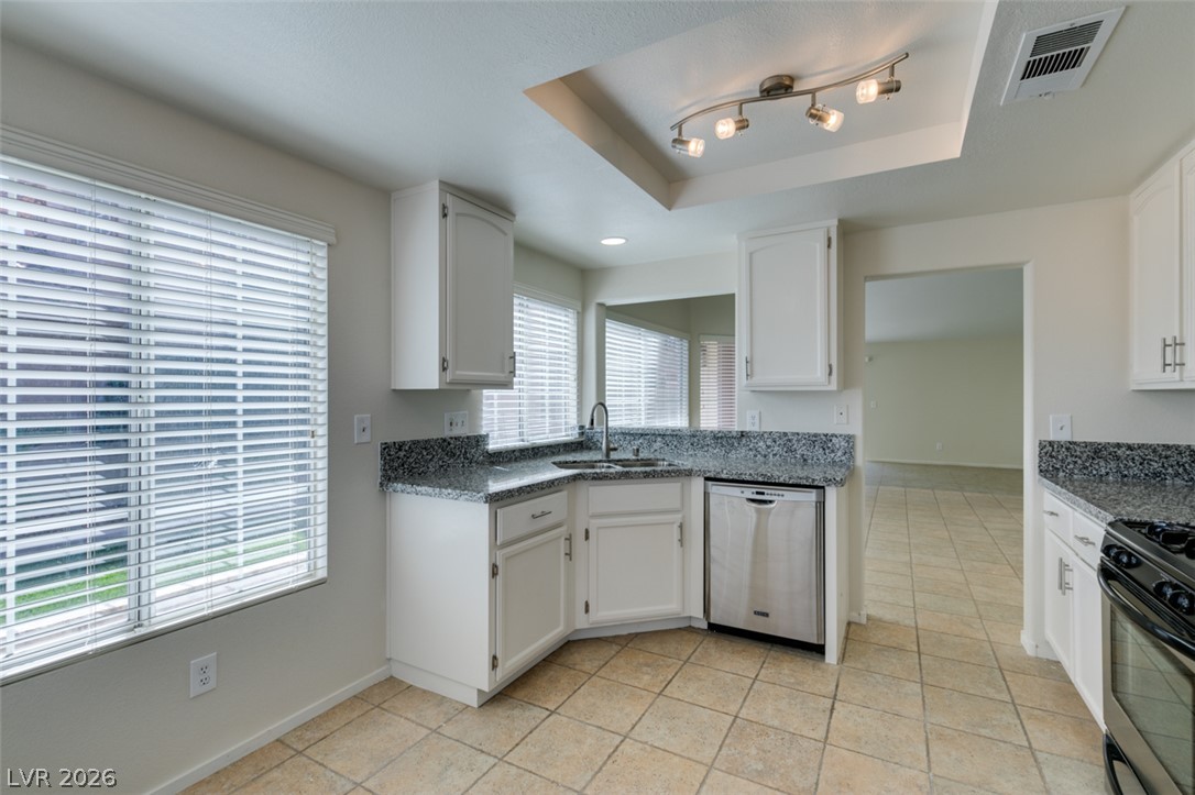 307 Cavalla Street Henderson, NV 89074 - Photo 26 of 44 Brightly lit kitchen with granite counters and white cabinetry for culinary pursuits.