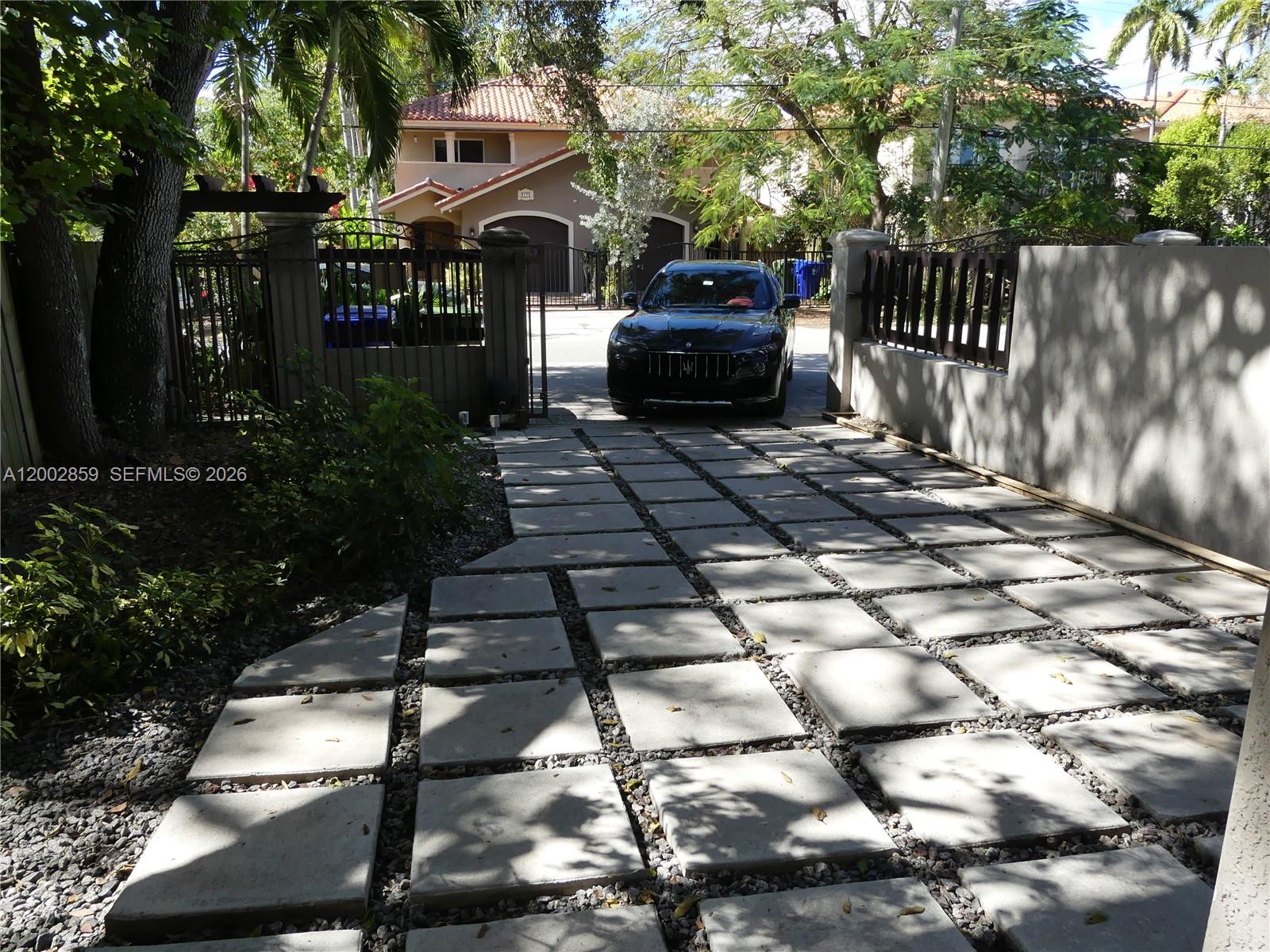 3171 Indiana Street, Unit 3171 Miami, FL 33133 - Photo 12 of 14 a view of a patio with table and chairs with wooden fence and plants