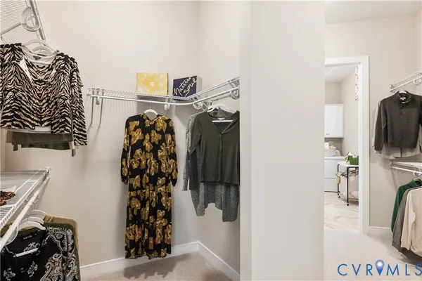 a view of walk in closet with clothes and shoes