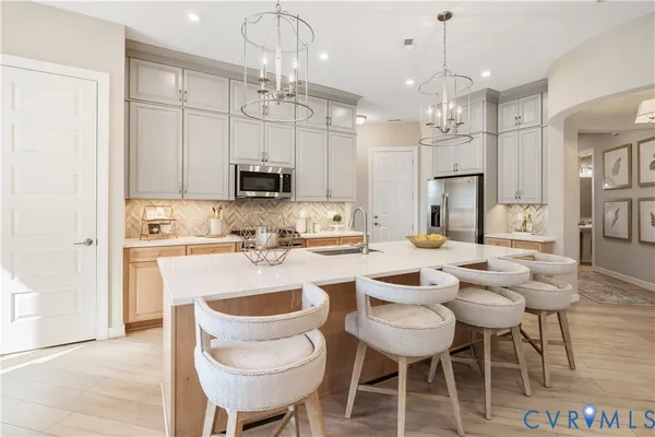 a kitchen with kitchen island a dining table and chairs