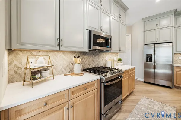 a kitchen with stainless steel appliances granite countertop a sink a stove a microwave and cabinets