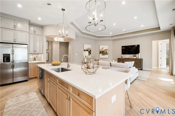 a large kitchen with kitchen island a sink and a refrigerator