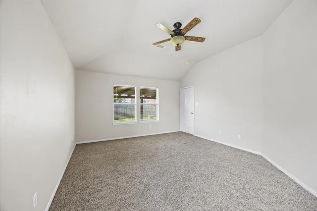 an empty room with a window and a ceiling fan