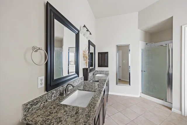 a large bathroom with a granite countertop tub a sink and a mirror