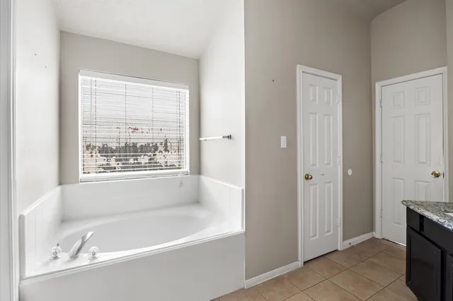 a white bath tub sitting in a bathroom next to a window