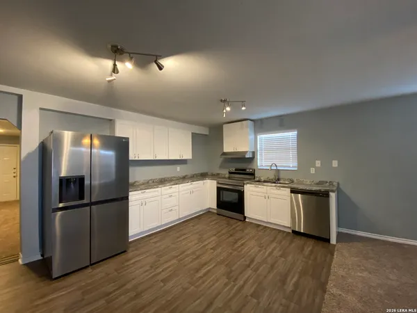 a kitchen with a refrigerator and a stove top oven