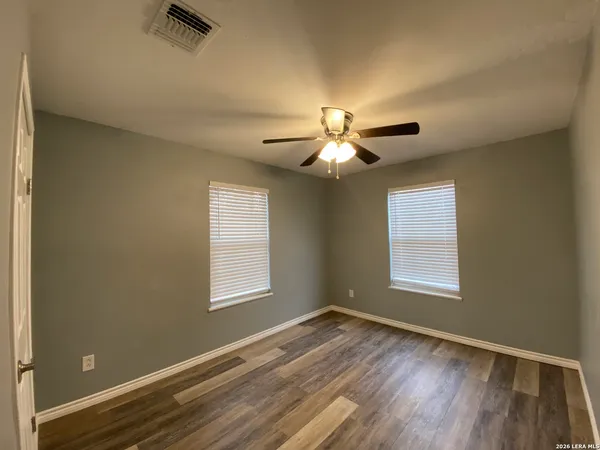 a view of empty room with window and wooden floor