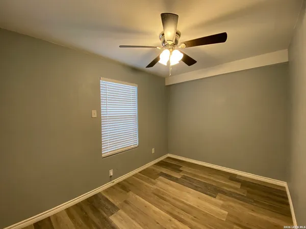 a view of a room with a ceiling fan and a window