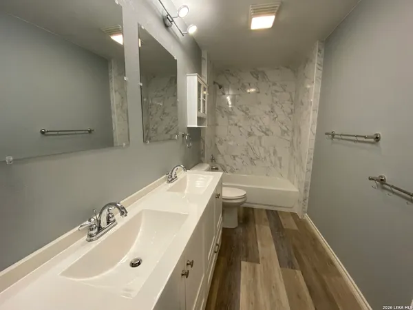 a bathroom with a sink a large mirror and shower