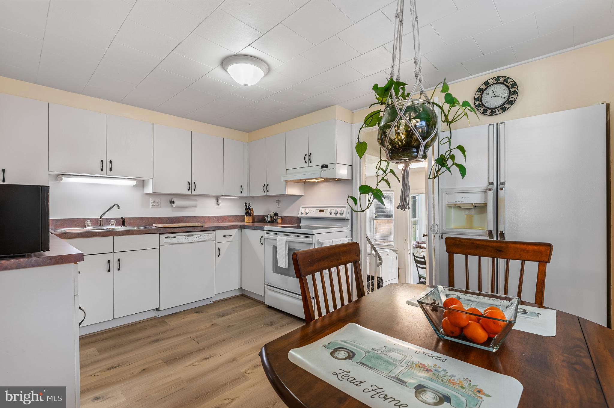 111 Compass Road Baltimore, MD 21220 - Photo 15 of 36 a kitchen with stainless steel appliances granite countertop a refrigerator a stove a sink dishwasher and white cabinets with wooden floor