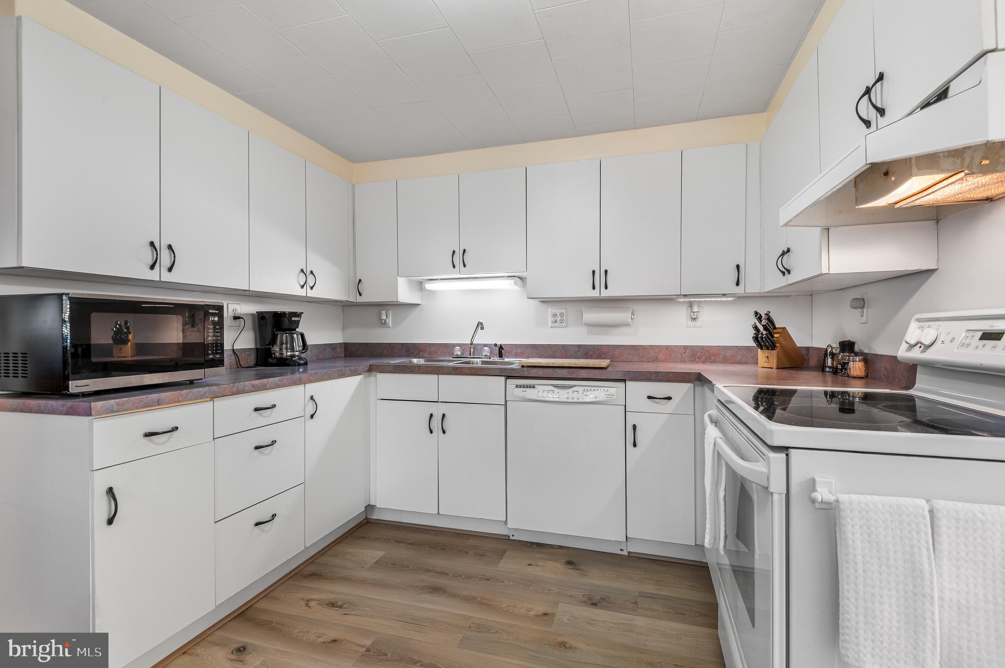 111 Compass Road Baltimore, MD 21220 - Photo 17 of 36 a kitchen with granite countertop white cabinets sink and stainless steel appliances