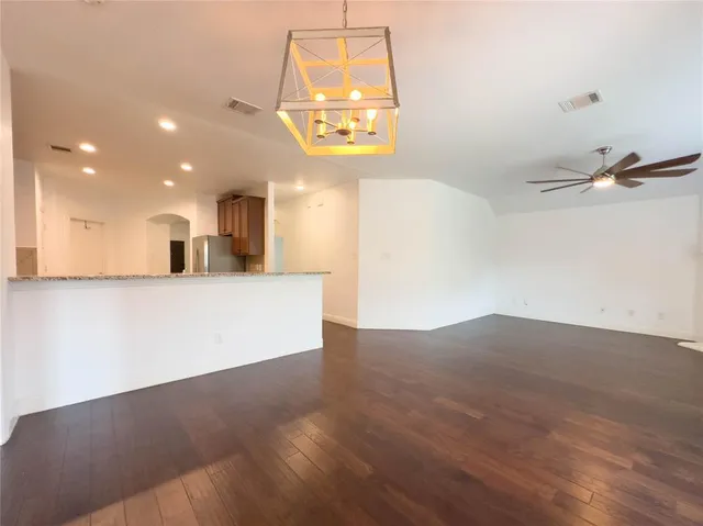 a view of a hallway with wooden floor and a window