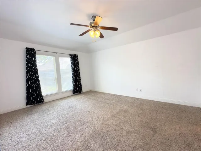 a view of empty room with ceiling fan