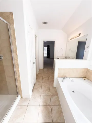 a bathroom with a tub shower and vanity
