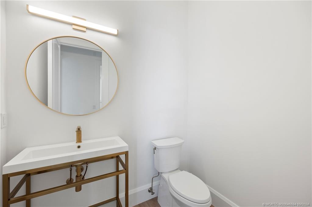 180 Beacon Lane Jupiter, FL 33469 - Photo 26 of 63 a bathroom with a toilet a sink and mirror