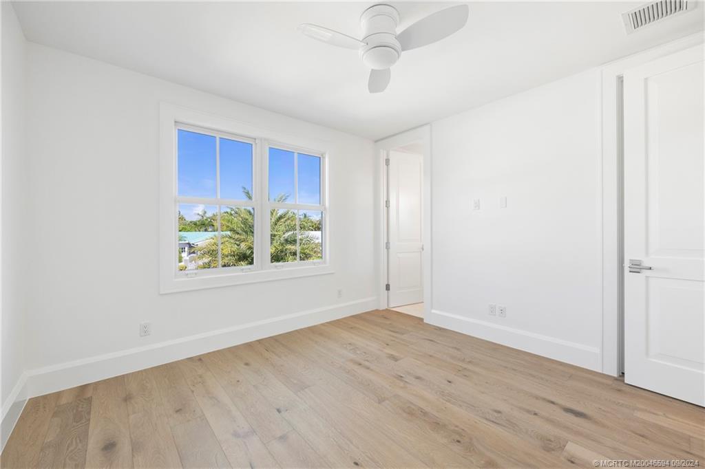 180 Beacon Lane Jupiter, FL 33469 - Photo 28 of 63 an empty room with window and wooden floor