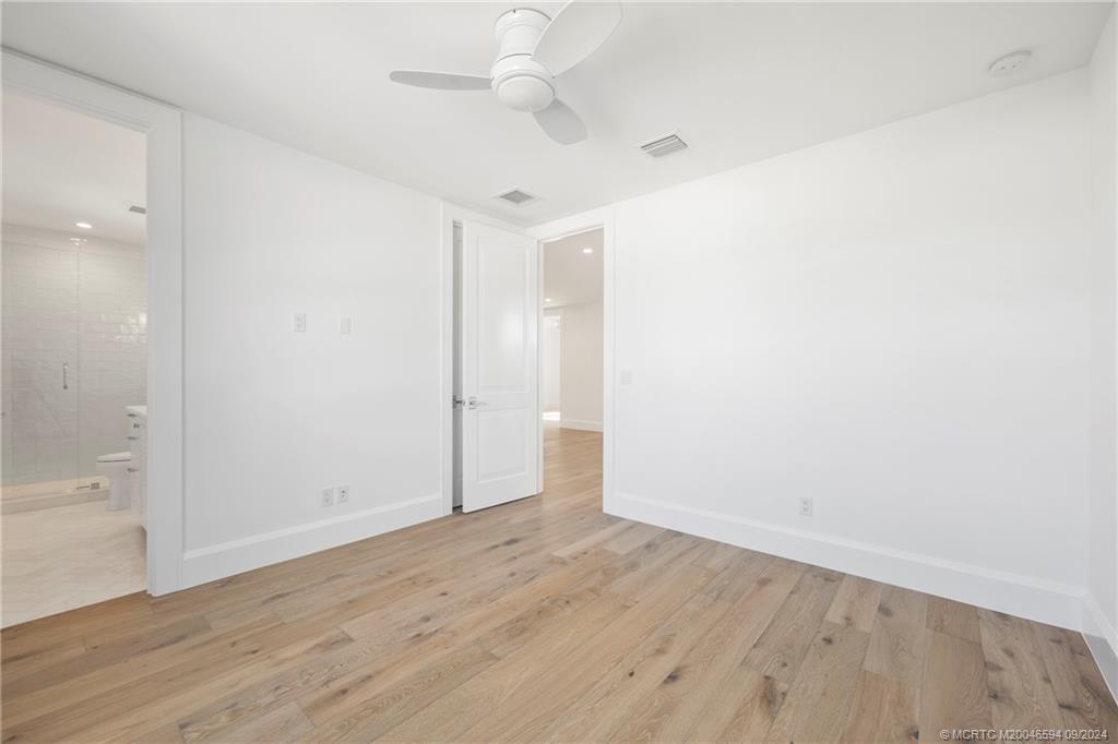 180 Beacon Lane Jupiter, FL 33469 - Photo 29 of 63 an empty room with wooden floor and fan