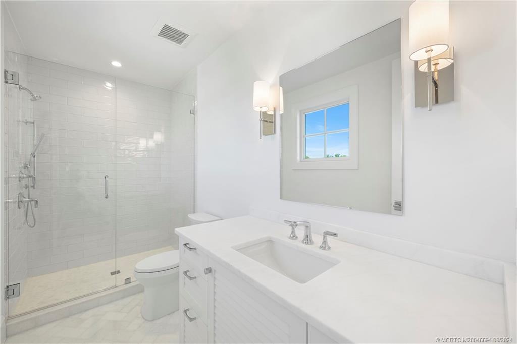 180 Beacon Lane Jupiter, FL 33469 - Photo 31 of 63 a bathroom with a sink a toilet and shower