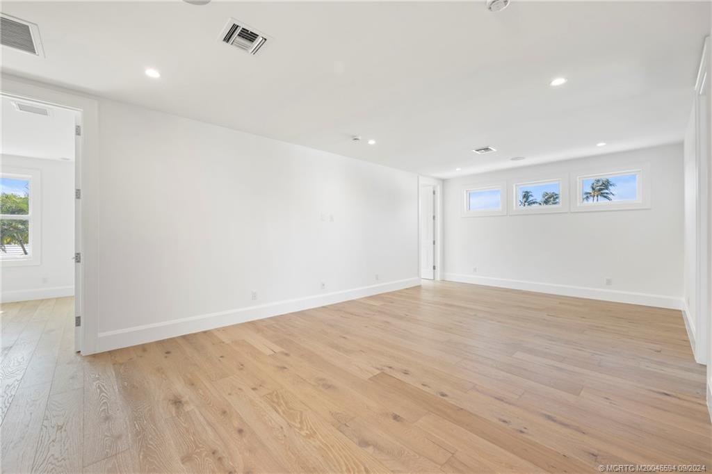 180 Beacon Lane Jupiter, FL 33469 - Photo 33 of 63 an empty room with wooden floor and windows