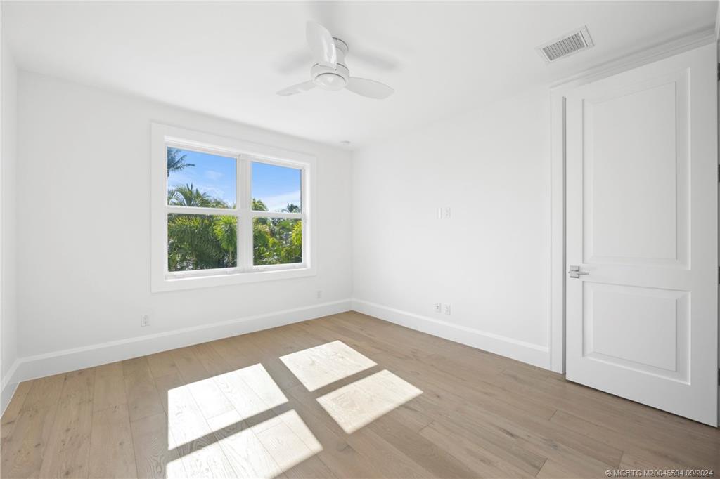 180 Beacon Lane Jupiter, FL 33469 - Photo 46 of 63 an empty room with wooden floor and windows