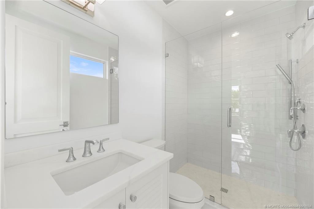 180 Beacon Lane Jupiter, FL 33469 - Photo 47 of 63 a bathroom with a sink vanity granite toilet and shower