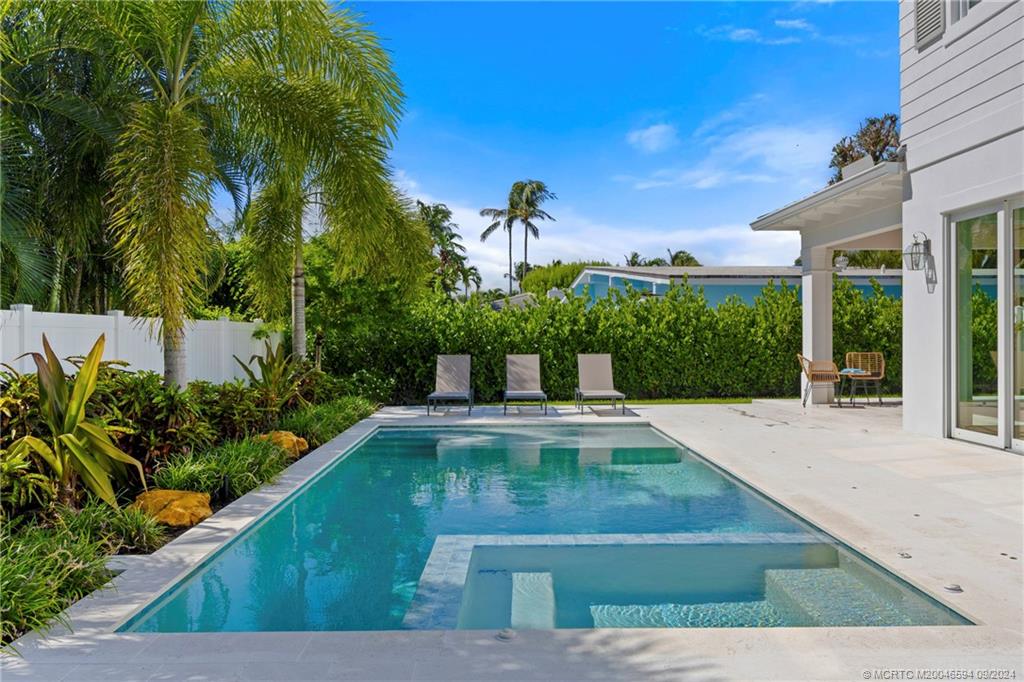 180 Beacon Lane Jupiter, FL 33469 - Photo 54 of 63 a view of a patio with plants and palm trees