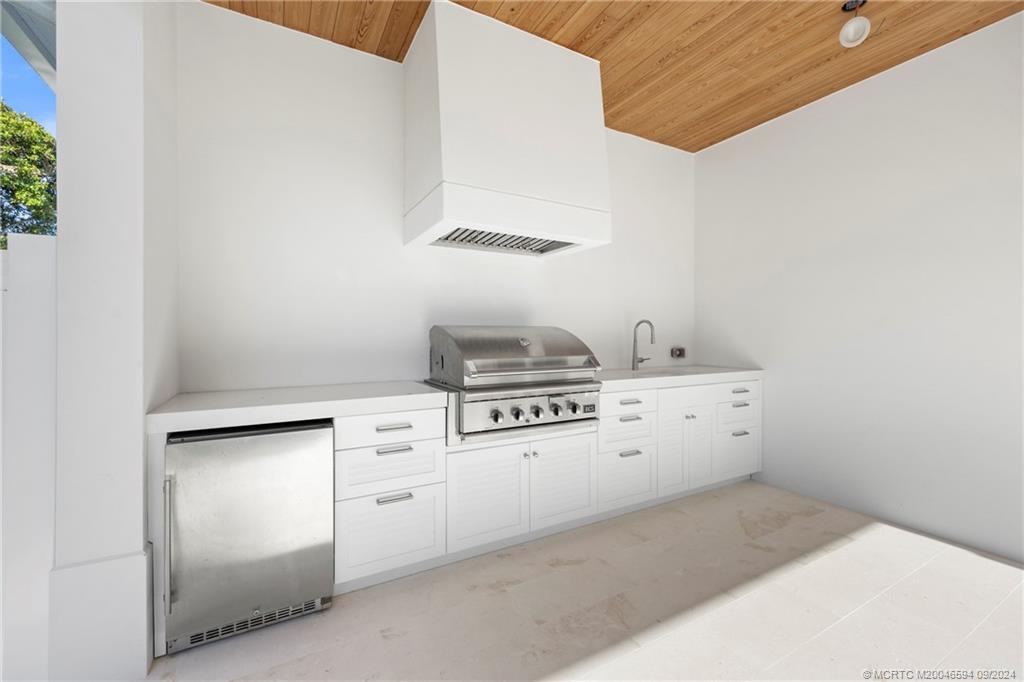 180 Beacon Lane Jupiter, FL 33469 - Photo 58 of 63 a kitchen with white cabinets and white appliances