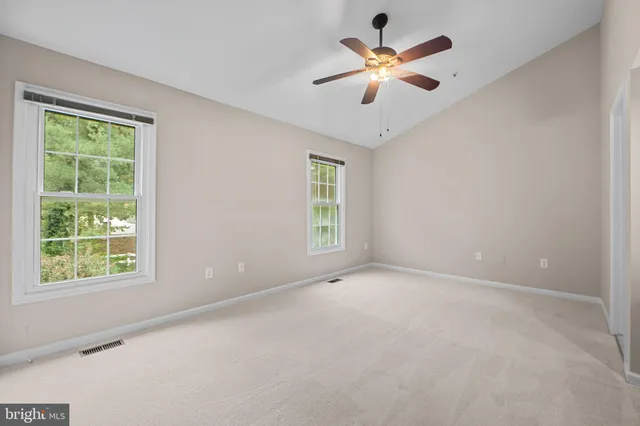 a spacious bedroom with a bed a window and a flat screen television