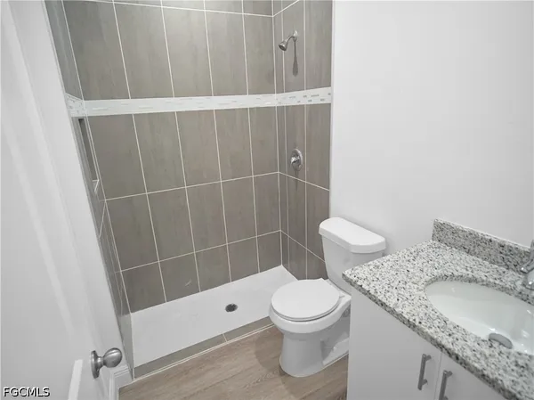 a bathroom with a granite countertop toilet and a sink