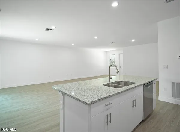 a kitchen with granite countertop a refrigerator stove and sink