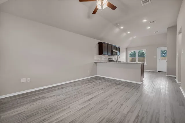 a view of kitchen and microwave with wooden floor