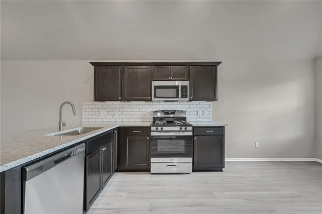 a kitchen with stainless steel appliances a stove and a sink