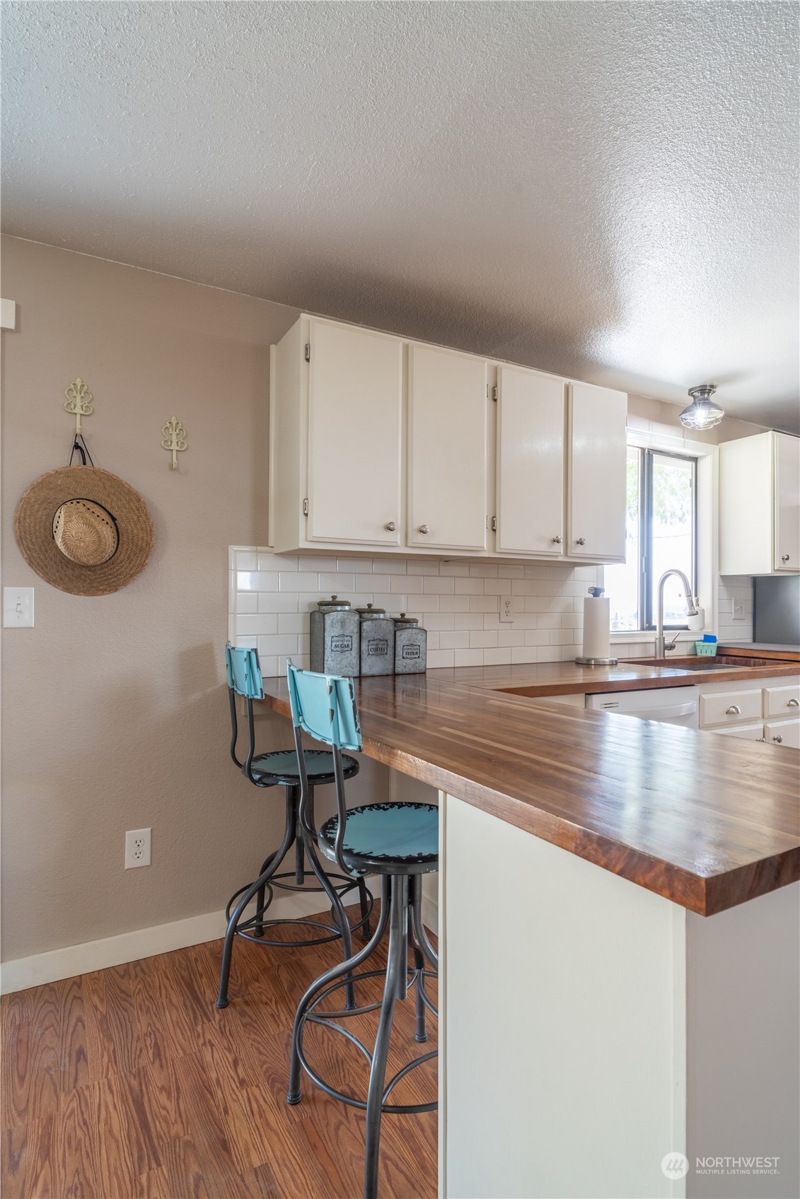102 East Herman Road Lind, WA 99341 - Photo 15 of 40 a kitchen with stainless steel appliances granite countertop a sink a stove and white cabinets with wooden floor