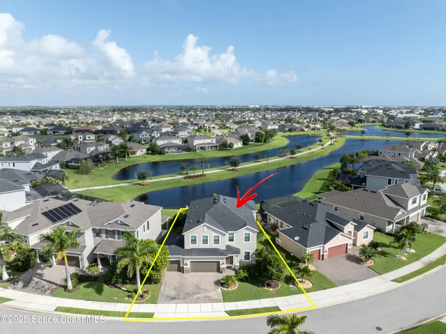 an aerial view of a house with a garden and lake view