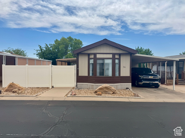 1360 North Dixie Downs Road, Unit 24 St. George, UT 84770 - Photo 1 of 1 Manufactured / mobile home with an attached carport, driveway, and a gate