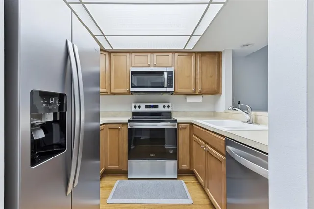a kitchen with stainless steel appliances granite countertop a stove microwave and a sink