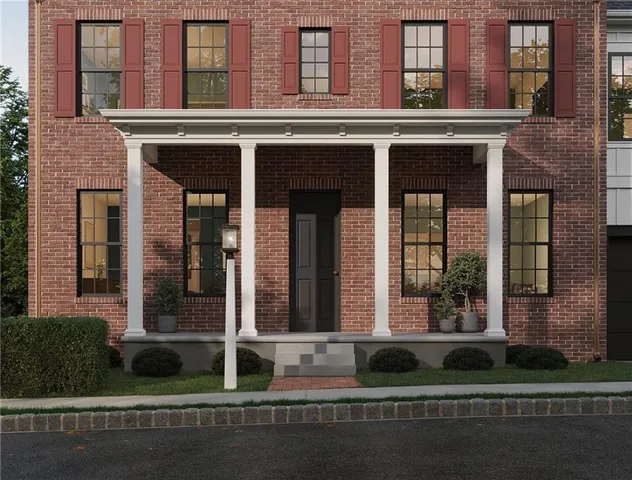 front view of a brick house with a yard