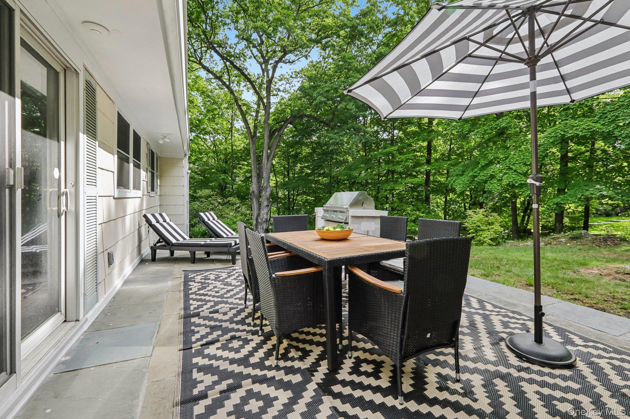 62 Mohegan Road Larchmont, NY 10538 - Photo 6 of 46 a view of a patio with a table and chairs under an umbrella