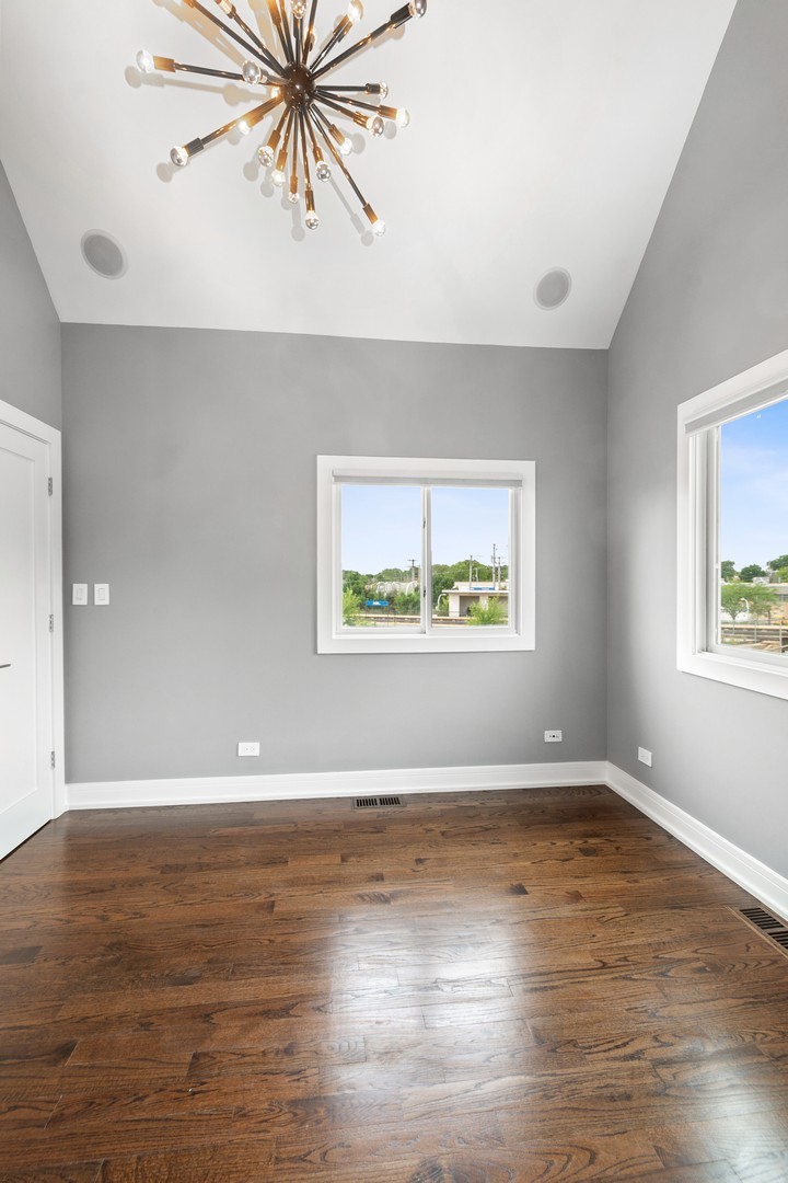3700 North Kenneth Avenue Chicago, IL 60641 - Photo 17 of 29 an empty room with wooden floor ceiling fan and windows