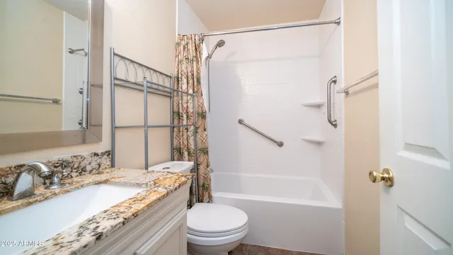 a bathroom with a granite countertop sink toilet and shower
