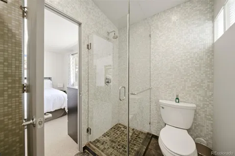 a large bed sitting in a bedroom next to a window