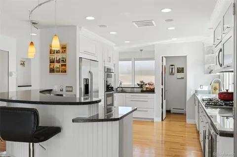 a kitchen with a refrigerator and white cabinets