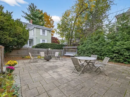 a view of a chairs and table in the back yard of the house