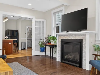 a living room with furniture a flat screen tv and a fireplace