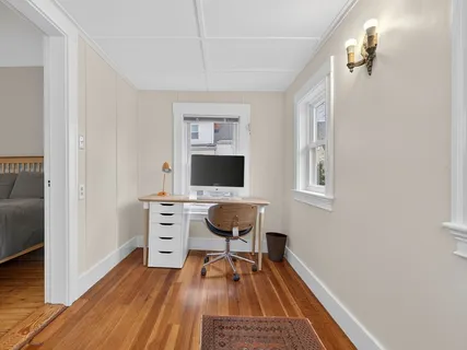 a view of a workspace with furniture and a window