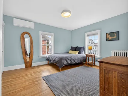 a bedroom with a bed and a dresser next to a window