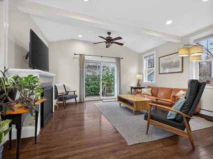 a living room with furniture a window and a flat screen tv
