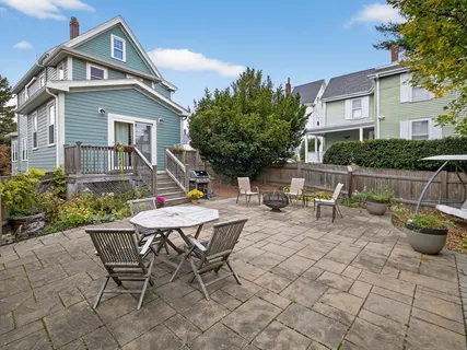a view of a house with patio chairs and tables