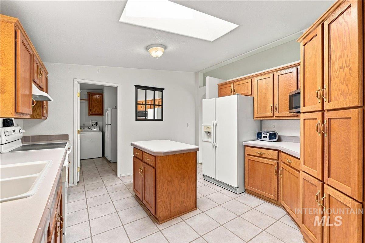 310 Frontage Road Grand View, ID 83624 - Photo 12 of 38 Kitchen featuring extensive wood cabinetry, a central island and a skylight